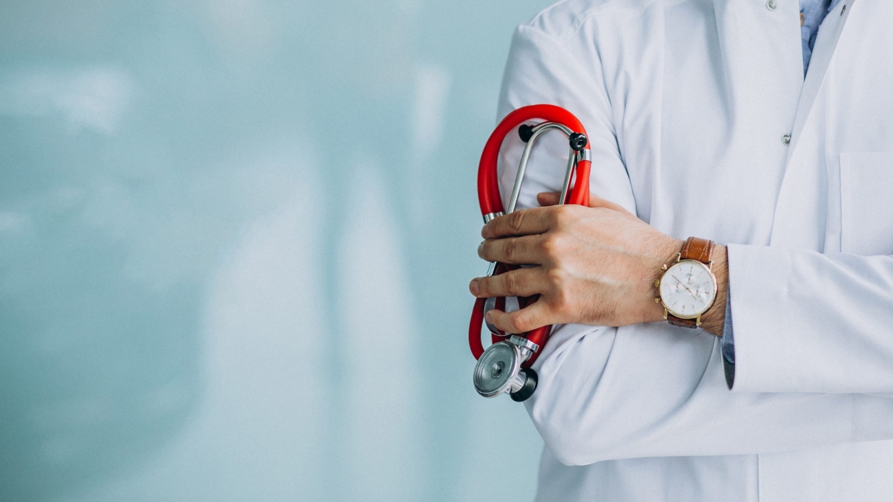 Young handsome physician in a medical robe with stethoscope