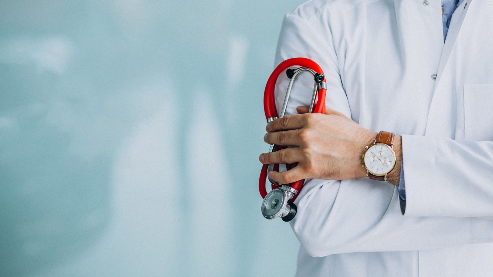 Young handsome physician in a medical robe with stethoscope
