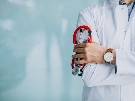 Young handsome physician in a medical robe with stethoscope